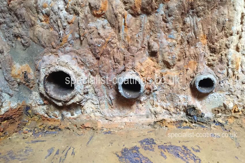 Rusty and leaking galvanised steel cold water tank. Before treatment with advanced corrosion and 30cm x 5cm hole. CWT Repair and lining service Specialist Coatings (GB) Ltd.